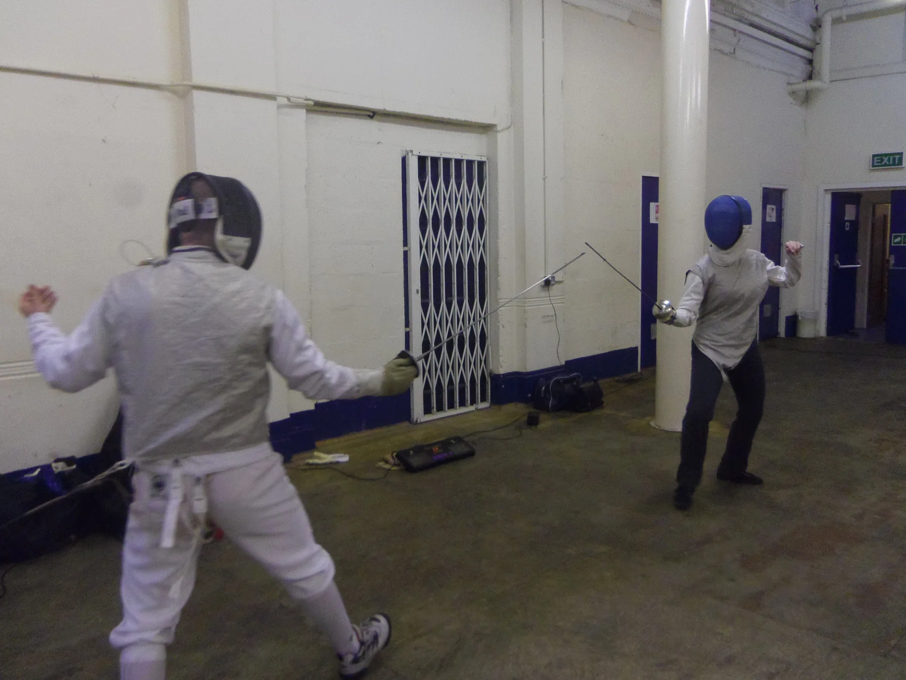 Foil fencers practising in the club hall