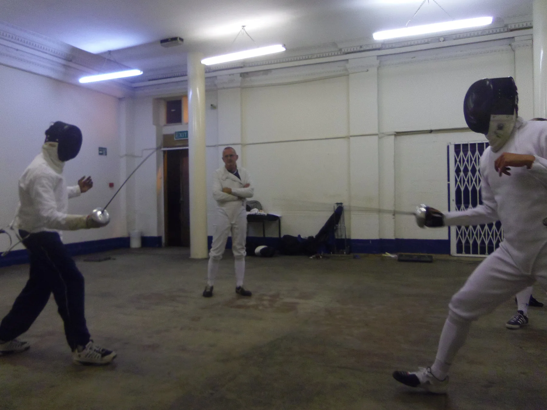 Three club members fencing in the practice hall
