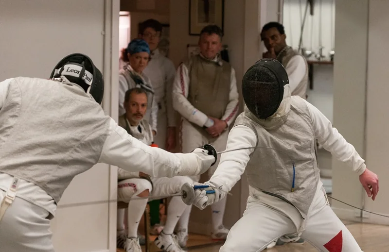 Two foil fencers meeting blade during a bout