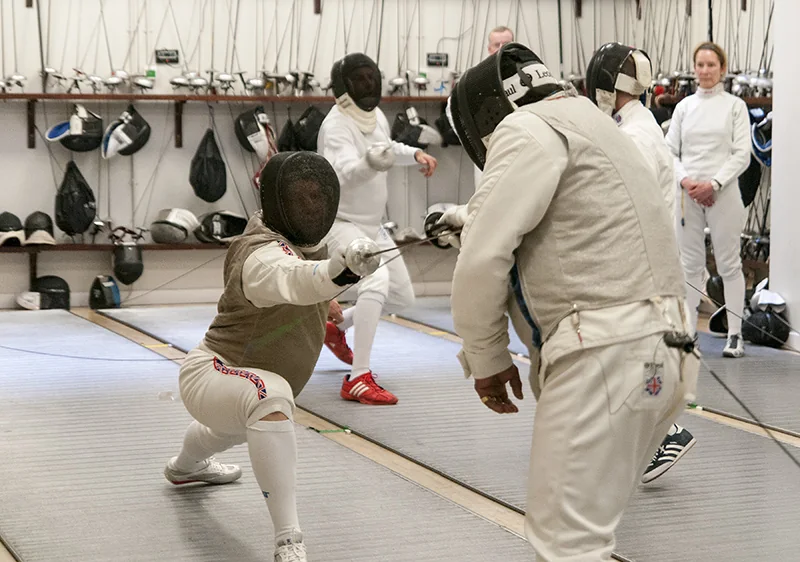 A fencer ducking beneath an opponent's attack