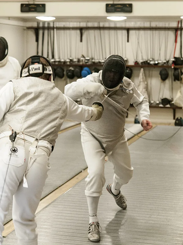 A foil fencer advancing during a bout
