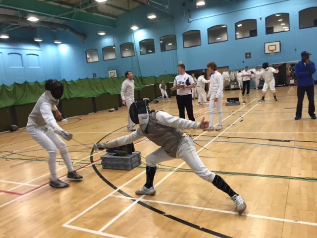A fencer making a deep lunge in competition