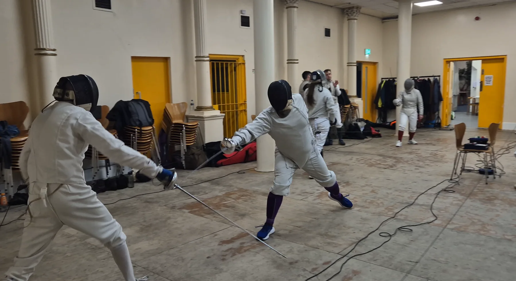 Two épée fencers exchanging hits during practice